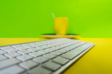 Portable placed on a yellow business workplace background table with yellow coffee cup.