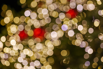 Gold and red Christmas light shiny abstract round bokeh on black background. Colourful Glitter bokeh from blurry decoration bulbs.