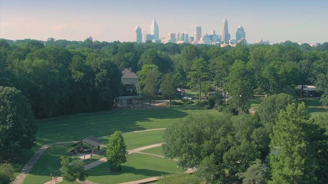 Aerial: Pond & fountain in Freedom Park, Charlotte. In the background is the city skyline. Charlotte, North Carolina, USA 