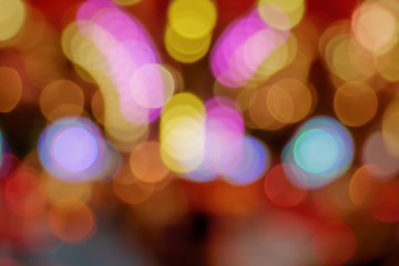 Fototapeta premium Golden and red Christmas light shiny abstract round bokeh on defocused background of celebration. Colourful Glitter bokeh from blurry decoration bulbs.