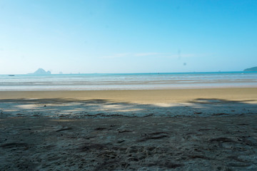 The beach by the sea has trees in Thailand.