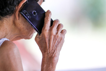 Old woman holding smart phone for shpping online