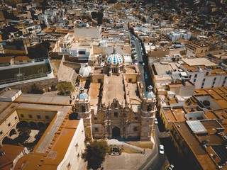 Aerial shot of a big cathedral in the middle of buildings Zacatecas Mexico