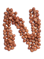 Letter N of the English alphabet from from hazelnut on a white isolated background. Food pattern made from nuts. Bright alphabet for shops.