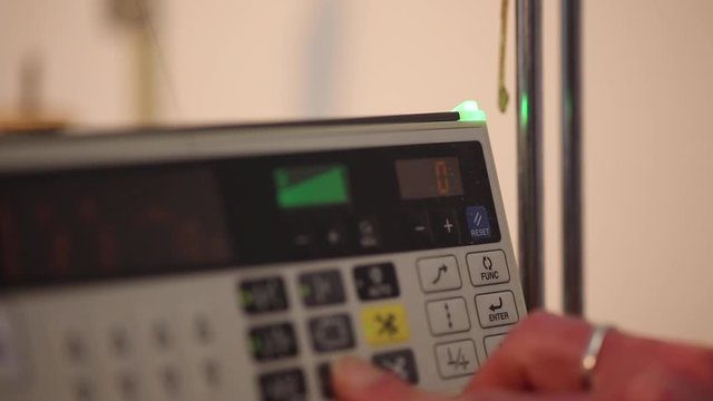 Close up of an industrial sewing machine control panel being switched on and programmed.