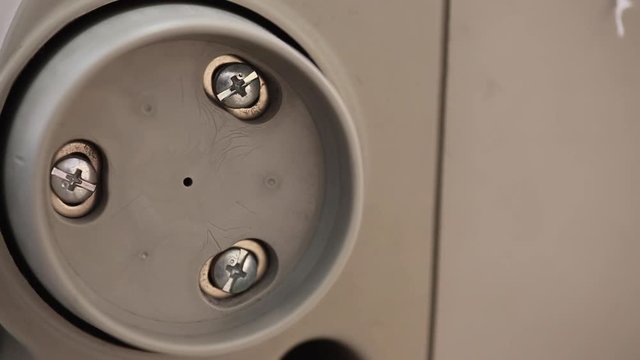 Extreme close up the wheel at the side of of an industrial sewing machine spinning whilst sewing