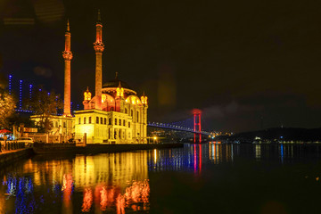 Obraz premium Istanbul, Turkey The Ortakoy Mosque under the Bosphorus Bridge, known officially as the 15 July Martyrs Bridge and unofficially as the First Bridge