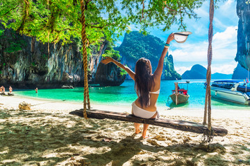 Happy traveler woman in bikini joy relaxing on swing in beautiful nature scenic landscape island,...