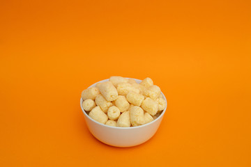Crunchy sweet corn sticks with powdered sugar in white bowl