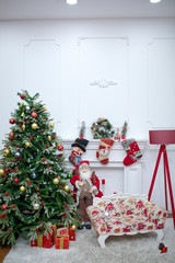 Mary christmas interior with new year pime tree decorated. Christmas red armchair and gifts. Santa Klaus . Christmas photozone decorated . Christmas with decorated a tree with Happy New Year on blue .