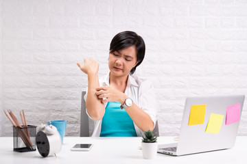 Woman scratching her skin at office