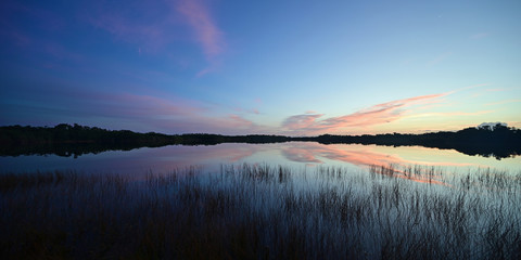 Sunrise cloudscape reflected on calm water of Nine Mile Pond in Everglades National Park, Florida.