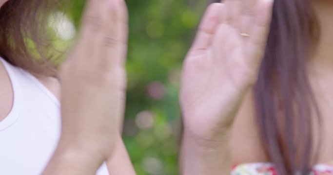 Close Up - Pan of two young women clapping their hands outside - shot on RED