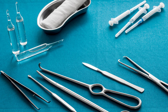 Plastic surgery instruments and tools with bandage and ampoulie on blue background copy space