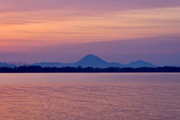 日の出直前のピンクに染まる空と琵琶湖の情景