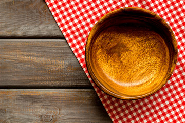Preparing for lunch - empty wooden bowl closeup on dark wooden background top view copy space