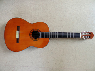 Fototapeta premium Classical six-string Acoustic Guitar on gray background. Selective focus.