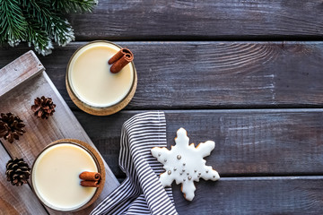 Eggnog - cute New Year composition with alcoholic drink on dark wooden background top view frame copy space