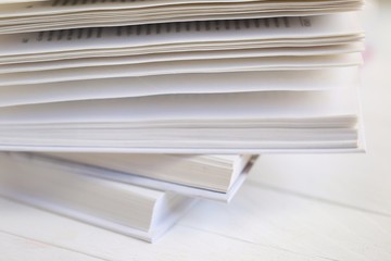 Winter books. Reading in the winter holidays. White cover books close-up on a white wooden table. Christmas books. Winter reading. White book background.