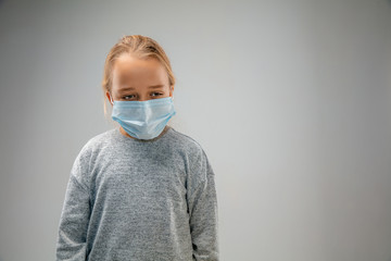 Sad future. Caucasian little girl wearing the respiratory protection mask against air pollution and dust particles exceed the safety limits. Healthcare, environmental, ecology concept.