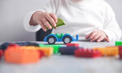 Little girl playing with toy car.