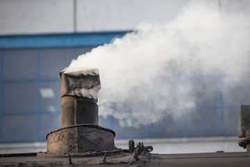 Smoke from the chimney flies into the atmosphere. The stove on the train