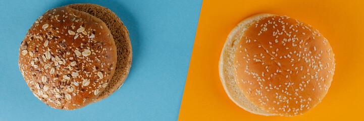Rye and classic bun empty isolated. American food classic rye round burger bread isolated on blue and orange background. Two different fried hamburger buns.Versus.
