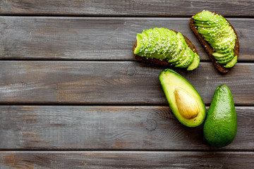 Healthy breakfast. Avocado toast on dark wooden background top view frame copy space