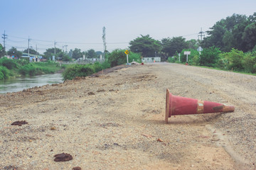 The old traffic cone falling on the road that was being repaired along the irrigation canal for...