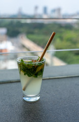 Close Up View of Mojito Drink with Straw With Skyline in the Background