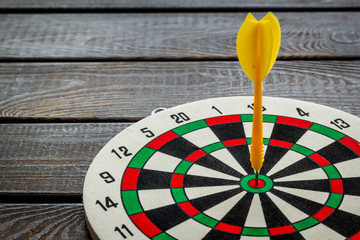 Goal achievement concept. Dartboard and arrows or dart on dark wooden background copy space