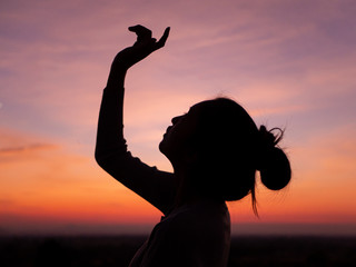 silhouette of young woman freedom feeling at sunset,thinking