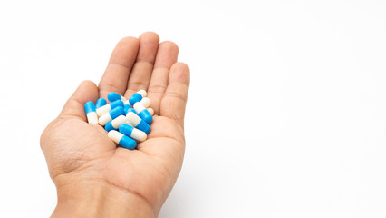 Medical drug capsule on hand on white background