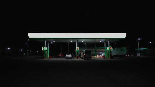 Timelapse Filling station at night. Cars are fueled with petrol on gasoline station. Business oil concept