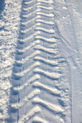 Traces of a car on white snow