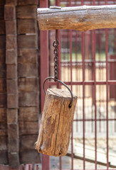 A wooden beam hangs on a metal chain