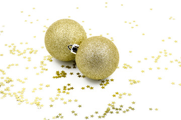Two golden christmas balls baubles on a white background with blurry golden stars