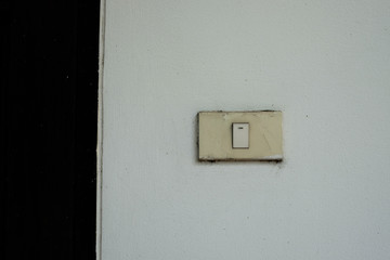 Old light switch on the white wall