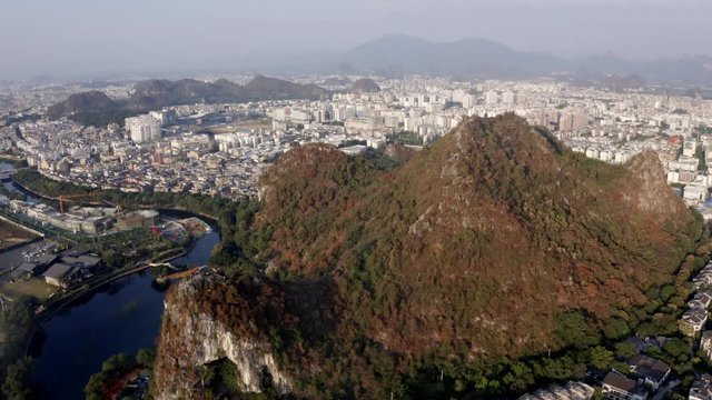 Densely populated Chinese Guilin city in mountain and river landscape, drone view