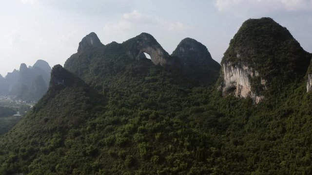 Moon Hill karst mountain natural arch reveal, China, drone pan view