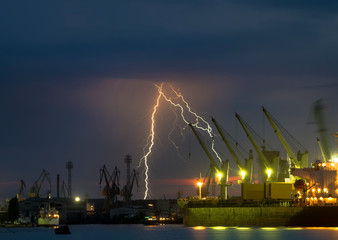 Naklejka na ściany i meble Thunderstorm with lightning over dockyard.