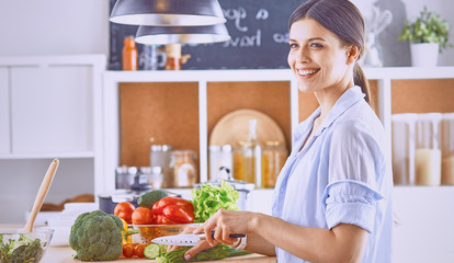 A young woman prepares food in the kitchen. Healthy food - vege