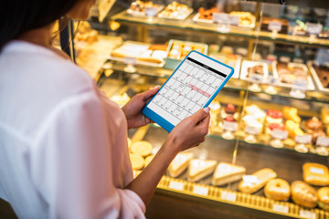 Close up of businesswoman holding tablet and checking her schedule