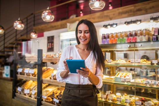 Cheerful young businesswoman ordering foods for her bakery