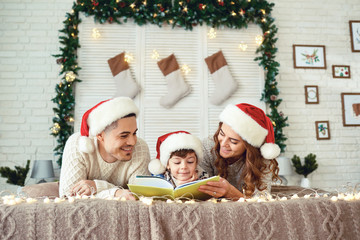 Cheerful family reading book in Christmas time