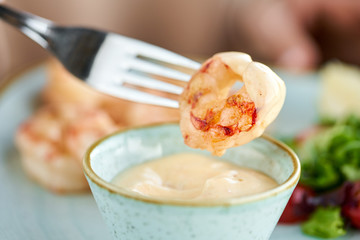 Grilled Argentine shrimp with mango-jalapeno sauce. Lunch in a restaurant, a woman eats delicious and healthy food. Delicious fresh seafood prawns with fresh vegetables and lime. Cream sauce