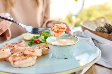 Grilled Argentine shrimp with mango-jalapeno sauce. Lunch in a restaurant, a woman eats delicious...
