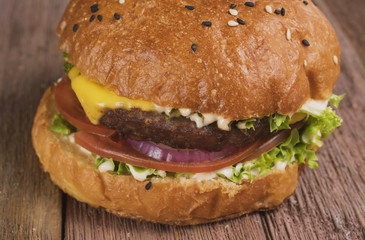 Cheeseburger on a wooden background with a glass of Mojito