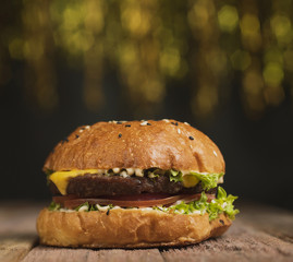 Cheeseburger on a wooden background with a glass of Mojito