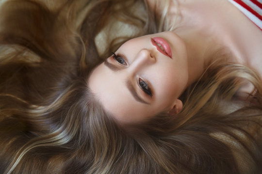 Portrait of a cute girl with long hair lying.
